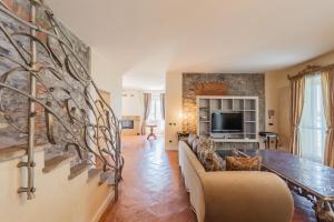 a living room with a couch and a tv at Luxury Villa in Tremezzo con piscina in Tremezzo