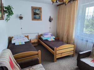 two twin beds in a room with a window at Agroturystyka u Mańka in Suwałki