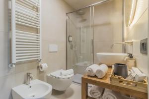 a white bathroom with a sink and a toilet at La Corte Del Lario - Contrada Scoscesa in Varenna +4 photos