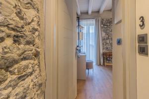a room with a stone wall and a hallway at La Corte Del Lario - Contrada Scoscesa in Varenna