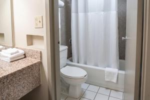 a bathroom with a white toilet and a shower at La Casa Inn Albany Near Tifton GA I 75 in Albany +26 photos
