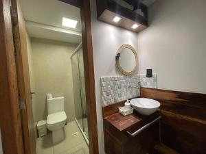 a bathroom with a toilet and a sink and a mirror at Hospedaria de Maria in Salvador