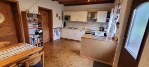 a kitchen with white cabinets and a table and a counter at Haus Alpaka in Bad König +8 photos