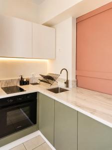 a kitchen with white cabinets and a sink at Noéma Mani Boutique Residences in Gythio +18 photos