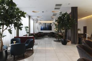 a lobby with chairs and tables and plants at Clarion Hotel Arlanda Airport Terminal in Arlanda +83 photos
