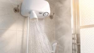 a shower with a shower curtain in a bathroom at Suíte no Centro de Caxambu - Poucos metros do Parque in Caxambu