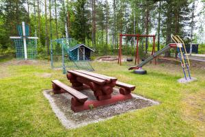 a park with a picnic table and playground equipment at Kyyronkaita in Mikkeli