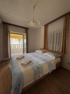 a bedroom with a large bed with a large window at Apartments Jela in Splitska