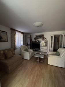 a living room with two couches and a tv at Apartments Jela in Splitska
