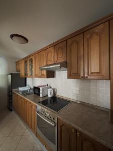 a kitchen with wooden cabinets and a stove top oven at Apartments Jela in Splitska