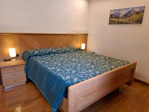 a bedroom with a bed with a blue comforter at Il Nido casa vacanze in Varena