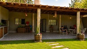 a man sitting in a chair under a pergola at El Indio - Casa de Campo con Piscina y Parrilla in Villa del Salvador