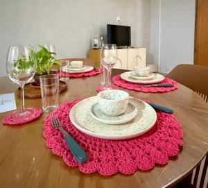 a wooden table with plates and dishes on a table at Flat Aconchego no Setor Oeste a 50m do Lago das Rosas, apto novo in Goiânia