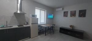 a kitchen with a sink and a table and a refrigerator at Уютная квартира в Одессе in Odesa