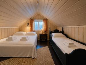 two beds in a room with a attic at Charming Cabin Near Hallingskarvet Ski Center, Cozy and Inviting! in Skoro
