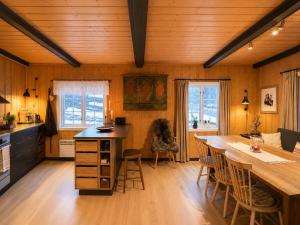 a kitchen and dining room with a table and chairs at Charming Cabin Near Hallingskarvet Ski Center, Cozy and Inviting! in Skoro