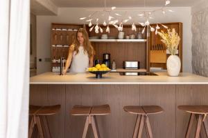 a woman standing at a kitchen counter with a bowl of fruit at Stone House Orsera II in Vrsar