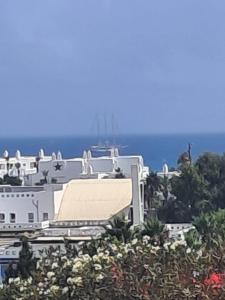 a white building on a hill with the ocean in the background at Appartement à m'diq in M'diq