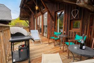 a screened in porch with a grill and tables and chairs at Top Floor Chalet Apartment in Saint-Jean-d'Aulps, Balcony in Saint-Jean-d'Aulps +28 photos