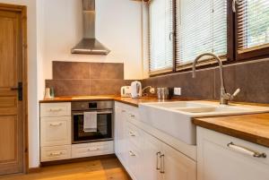 a kitchen with white cabinets and a sink at Top Floor Chalet Apartment in Saint-Jean-d'Aulps, Balcony in Saint-Jean-d'Aulps