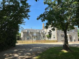 an old stone house with a tree in front of it at The Little Vicarage in Highbridge