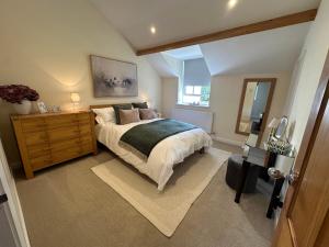 a bedroom with a bed and a dresser and a mirror at The Little Vicarage in Highbridge