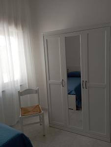 a bedroom with a mirror and a chair and a closet at Una Terrazza sul mare in San Ferdinando