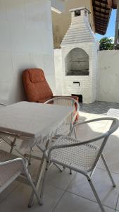 a table and chairs on a patio with a pizza oven at Casa Harmonia in Trairi