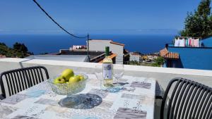 a table with a bowl of fruit and a bottle of wine at Casa Gustavo Apartman in La Guancha