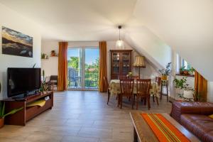 a living room with a couch and a dining room at Dolistówka Apartamenty z jacuzzi i sauną in Goniadz