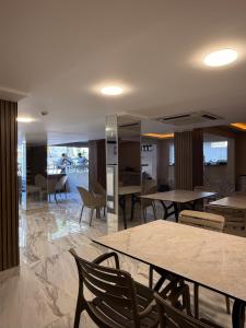 a dining room with tables and chairs and a room with tables at Livane Beach Hotel in Alanya