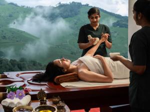 a woman is getting a massage at a spa at 1924 Clock House Munnar in Munnar