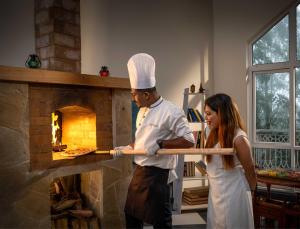 a man and a woman standing in front of a brick oven at 1924 Clock House Munnar in Munnar +17 photos