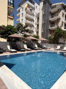 a swimming pool with lounge chairs and a building at Livane Beach Hotel in Alanya +47 photos
