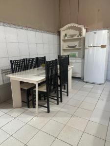 a kitchen with a table and chairs and a refrigerator at Casa Harmonia in Trairi