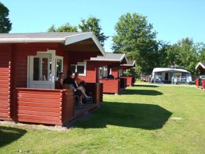 a group of people sitting on the porch of a cabin at Morsø Camping in Nykøbing Mors