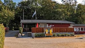 a red building with a flag on top of it at Morsø Camping in Nykøbing Mors