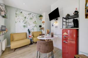 a kitchen with a table and two chairs and a red refrigerator at Comme à la maison in Ducey
