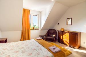 a bedroom with a bed and a chair at Dolistówka Apartamenty z jacuzzi i sauną in Goniadz
