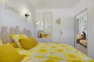a bedroom with a yellow bed with yellow pillows at Comme à la maison in Ducey