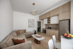 a living room with a couch and a kitchen at Ierapetra’s Mosque House in Ierapetra