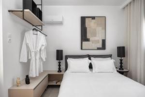 a bedroom with a white bed and a dresser at Ierapetra’s Mosque House in Ierapetra +24 photos