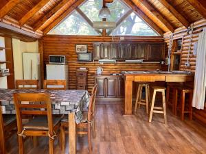 a kitchen with wooden cabinets and a table and chairs at La Posada del Hobbit in Villa Ventana