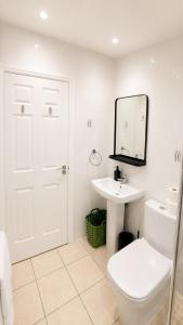 a white bathroom with a toilet and a sink at Cosy Flat on the Top Floor in Ramsbottom in Ramsbottom
