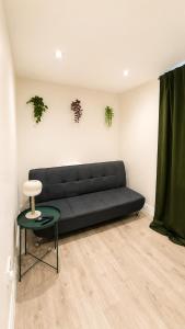 a living room with a black couch and a table at Cosy Flat on the Top Floor in Ramsbottom in Ramsbottom +2 photos