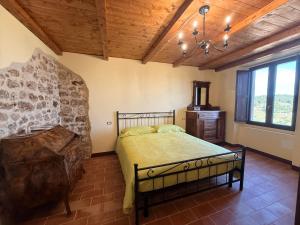 a bedroom with a bed and a wooden ceiling at Arcem in Calascio