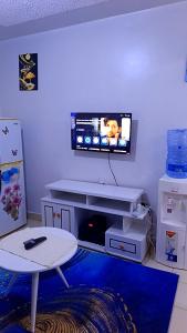 a living room with a tv on a wall at Classic in Narok
