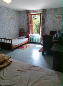 a bedroom with a bed and a window at Maisonnette de village in Mosnes
