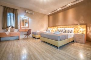 1 dormitorio con 2 camas, escritorio y espejo en Fiorentinos Villa, en Tragaki
