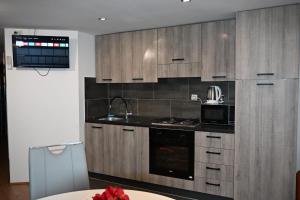 a kitchen with wooden cabinets and a stove top oven at Leona in Senj